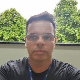 Foto de Dr. Alessandro, usando óculos e camisa preta, olhando para a câmera com expressão neutra.